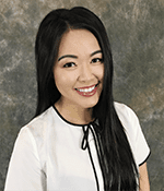 Smiling person with long black hair, white blouse