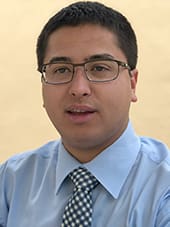 Person wearing glasses, blue shirt and tie