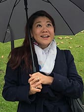 Woman holding umbrella looking upward